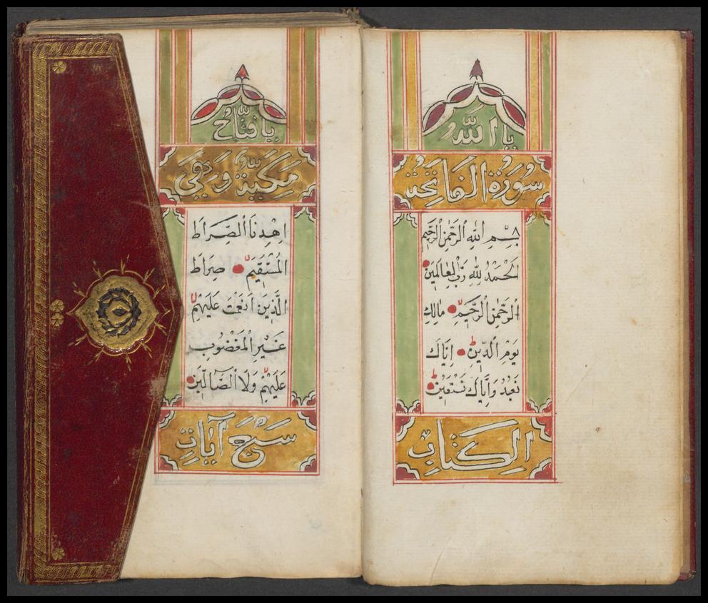 Das Bild zeigt den aufgeschlagenen Koran, dessen Seiten mit einem gelb, grün, rotem Muster verziert sind. An der linken Seite ist der Klappdeckel zu sehen, welcher mit einem rot, golden gestaltet ist.