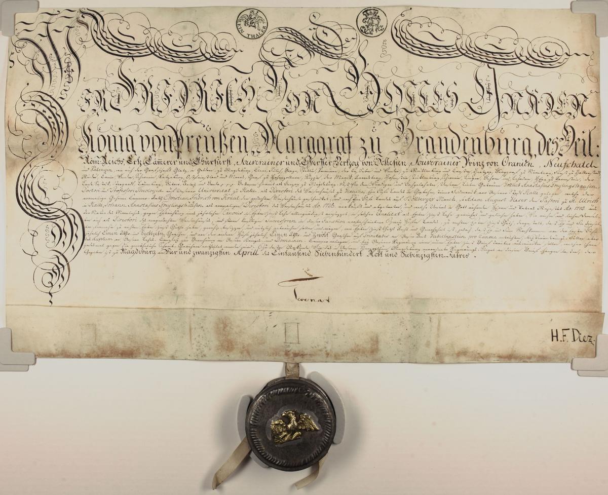 Das Bild zeigt die Pergamnenturkunde mit Auszeichnungsschrift und der Siegelkapsel aus Metall. Darauf ist der preußische Adler in Gold zu sehen.
